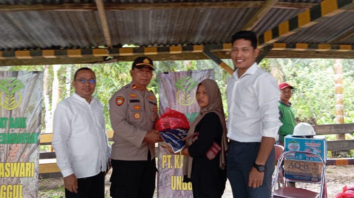 Kapolsek Dendang, IPTU Sunarto dan Pimpinan PT Kaswari Unggul saat membagikan bantuan paket sembako kepada masyarakat, Sabtu (22/3/2025). FOTO : bj